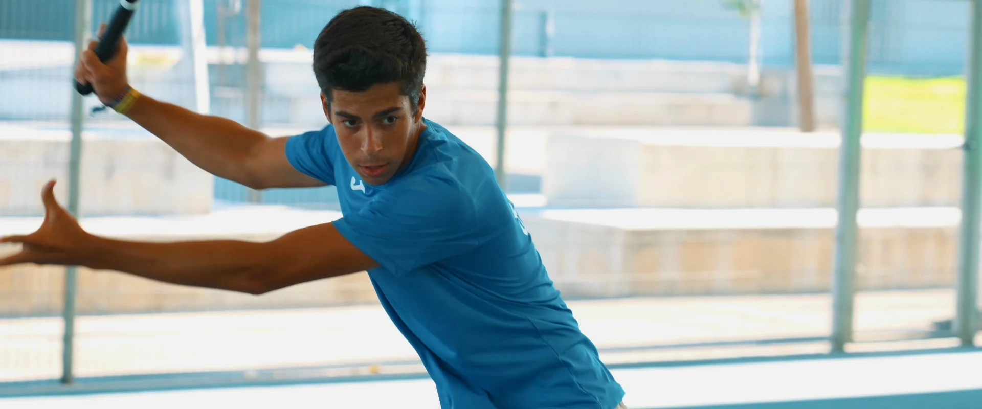 Atleta do clube em ação num court de ténis